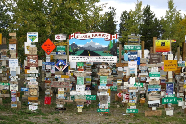 You cycle past Watson Lake famed for its signpost of license plates from around the world